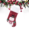 Détail d'une chaussette de Noël rouge brodée d'un bonhomme de neige sur des branches de sapin - Bonhomme de neige