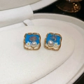 Vue macro de boucles d'oreilles carrées dorées avec insert bleu, perle et motif marguerite - Style Petite Marguerite Carrée Bleue (22# Tige en Argent-Bleu-Carré)