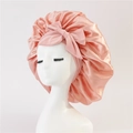 Detail of a pink satin silk sleep bonnet with a large decorative bow on a white mannequin - Medium Single Layer Ribbon / Off White