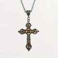 Dettaglio macro della collana a croce gotica in argento con incisioni e pietre ambra - Arancione