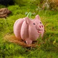 Pink pumpkin pig latex dog toy with matte texture in a natural moss nest scene - Pink Pumpkin Pig
