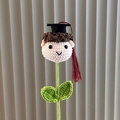 Handcrafted crochet graduation boy with black mortarboard and red tassel on green stem - Doctoral Cap Boy