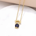 Macro shot of gold-plated necklace with a blue heart-shaped zircon pendant - Girl Style / 18K Gold / Dark Blue