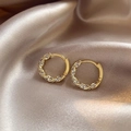 Golden twisted hoop earrings with micro-pave crystals on champagne satin background - Zircon Rotating Twisted Pattern / Gold