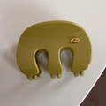 Detailed top view of green hair claw clip with golden Love logo plate on a white surface - Wavy M-Shaped / Green