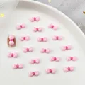 Roze strikjes van hars voor schattige doe-het-zelf nageldecoratie op wit dienblad - Roze