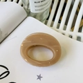 Macro detail of oval cream-colored hair claw clip with smooth texture on white book - Approx 7cm / Deep Nude Pink