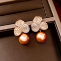 Detalle de pendiente floral dorado con circonitas pavé y una perla dorada brillante - Chapado en Oro Champán
