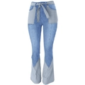 Dettaglio dei jeans a zampa patchwork a vita alta con cintura a fiocco e grandi tasche - S / Azzurro