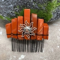 Detail of reddish stones and silver sun charm hand-wrapped on a metal hair comb - Red Jasper Black Wire Silver Sun