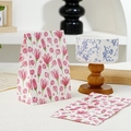 Detail view of mini paper gift bag featuring soft pink watercolor floral patterns - Red Flower