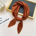Elegant caramel pleated neck scarf with fine texture displayed on a gold tray - Caramel color