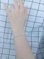 Dettaglio di un bracciale tennis argento con zirconi cubici quadrati pavé al polso - Braccialetto quadrato con strass