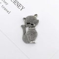 Macro shot of silver zinc alloy cat charm with dotted texture on a white travel card - Antique Silver