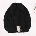 Detail view of a black knit beanie with hollow leaf pattern and lace button trim. - Adjustable / Black