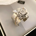 Makroaufnahme eines silbernen Metallarmreifs mit detailgetreuer 3D-Rosenblüten-Skulptur - Rosenstrauß Offenes Armband / Silber