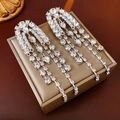 Primer plano de pendientes de plata con cristales de gota y detalles de borlas largas - Plata (Pin de plata)