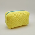 Detailed view of yellow plush pencil case featuring 3D heart quilted texture and blue zipper - Yellow