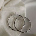 Silver twisted metal hoop clip-on earrings with transparent cushion on white fabric - Silver Twisted Hoop Ear Clip