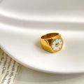Macro detail of gold signet ring with a white enamel daisy on a hexagonal face - US 6 / White Daisy