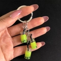 Close-up of mini green bubble tea keychain charms with realistic resin liquid and silver ring - Light Green