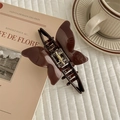 Brown acetate butterfly hair claw clip with metal spring on a vintage French book - Brown