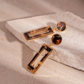 Close-up of vintage leopard resin earrings with gold metal frame on a stone stand - Leopard Print Rectangular Drop Earrings (Silver Pin)