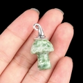 Green and white spotted stone mushroom pendant with silver clasp held in hand - Gun Black Cap / Qinghai Jade