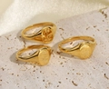 Detailed view of three 18K gold-plated floral signet rings on a textured stone surface - US 6 / Gold 4