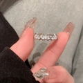 Dettaglio ravvicinato di un anello geometrico argento con intarsio di zirconi lucidi - Anello regolabile stile 3