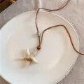 Détail du collier pendentif étoile de mer avec cordon marron et perles sur assiette céramique - 10# Collier-Café-Étoile de Mer