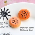 Macro detail of 22mm orange resin miniature pastry with sesame seeds for DIY crafts - Black Sesame Bread