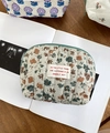 Gesteppte Kosmetiktasche mit Blumenmuster und grünem Reißverschluss auf dem Tisch - Ballonblume