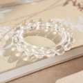 Gros plan d'un bracelet en perles de cristal blanc posé sur un livre en tissu au style vintage - 10mm-Coffret Cadeau Exquis