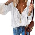 Detailed view of bohemian white lace blouse with deep V-neck and tassel tie accents - S / White