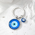 Detailed view of the Evil Eye Protection keychain with blue glass pendant and silver frame - Letter Protection Blue Round Eye