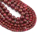 Macro shot of polished red natural stone beads with golden veins in various sizes - Red Cloisonne Style