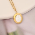 Detailed close-up of a gold oval pendant with white shell inlay on a pearl chain - Gold Oval Mother of Pearl Style (10#)