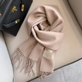 Beige 100% Australian wool scarf with fringe detail on a leather background - Shrimp Color