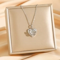 Collier avec pendentif cœur argenté et relief papillon sur présentoir élégant - Papillon argenté