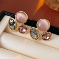 Macro detail of vintage gold earrings featuring pink cat eye stone and faceted crystals - Purple (Silver Earring Post)