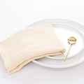 Minimalist beige linen cotton napkin neatly folded on white plates with golden cutlery - Ivory