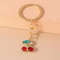 Portachiavi con ciliegie di strass rossi scintillanti, finitura dorata e foglie verdi - Ciliegia con Intarsi di Strass