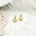 Macro shot of gold star charms with cubic zirconia on white lace and feather background - Zircon Star