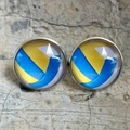 Gros plan de boucles d'oreilles en verre volleyball avec cadre argenté sur béton - Volley-ball