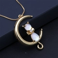 Collana dorata con luna crescente e volpe in opale bianco su sfondo scuro - Bianco