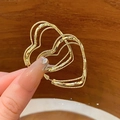 Gelaagde gouden hartoorbellen met gedraaide touwtextuur vastgehouden in de hand - Gouden hartstijl (Zilveren oorbellenstift)