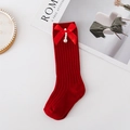 Dettaglio di calze alte rosse lavorate a maglia con fiocchi di raso e perle - XS (0-1 Anni) / Rosso