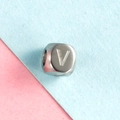 Pendentif carré en acier inoxydable argenté avec lettre V gravée sur fond pastel - Lettre V