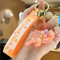 Orange bubble tea keychain with liquid oil, bear floating charm, and silicone strap - Bead Lollipop - Orange